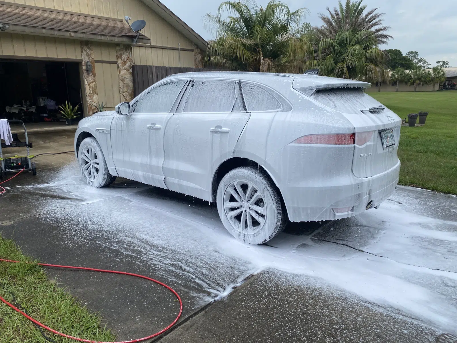 White SUV covered in foam during a driveway wash — Performance Mobile Detail in Ocala