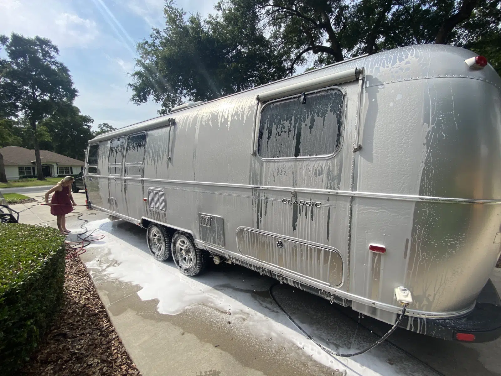 Soapy Airstream travel trailer being washed in a driveway — Performance Mobile Detail in Ocala