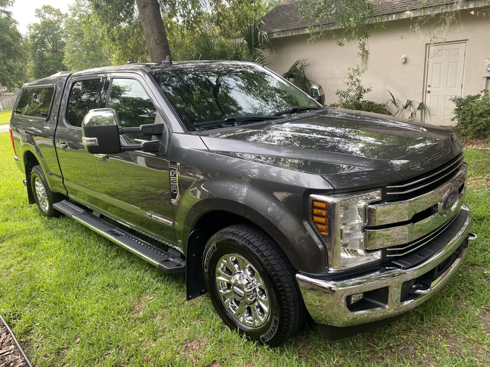 Detailed gray Ford truck with chrome wheels on a lawn — Performance Mobile Detail in Ocala